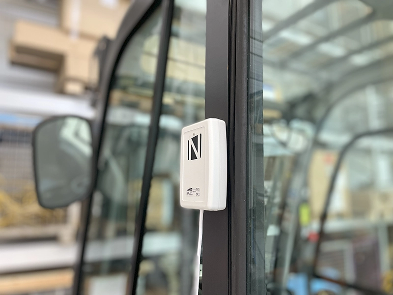 NAiSE UWB tag mounted on the exterior frame of an industrial vehicle for real-time location tracking.