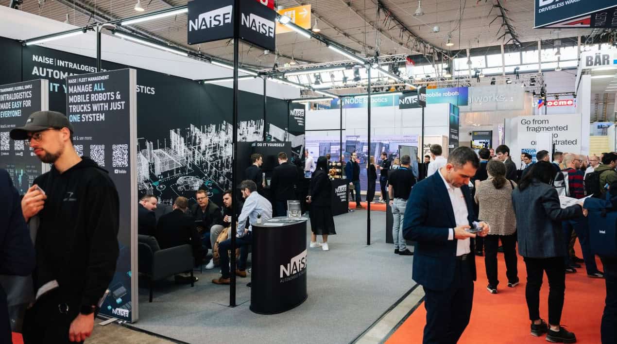 NAiSE exhibition booth at the LogiMAT trade show, with staff and attendees on the show floor
